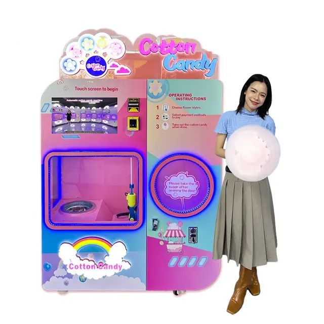 Woman holding cotton candy next to a colorful cotton candy vending machine.